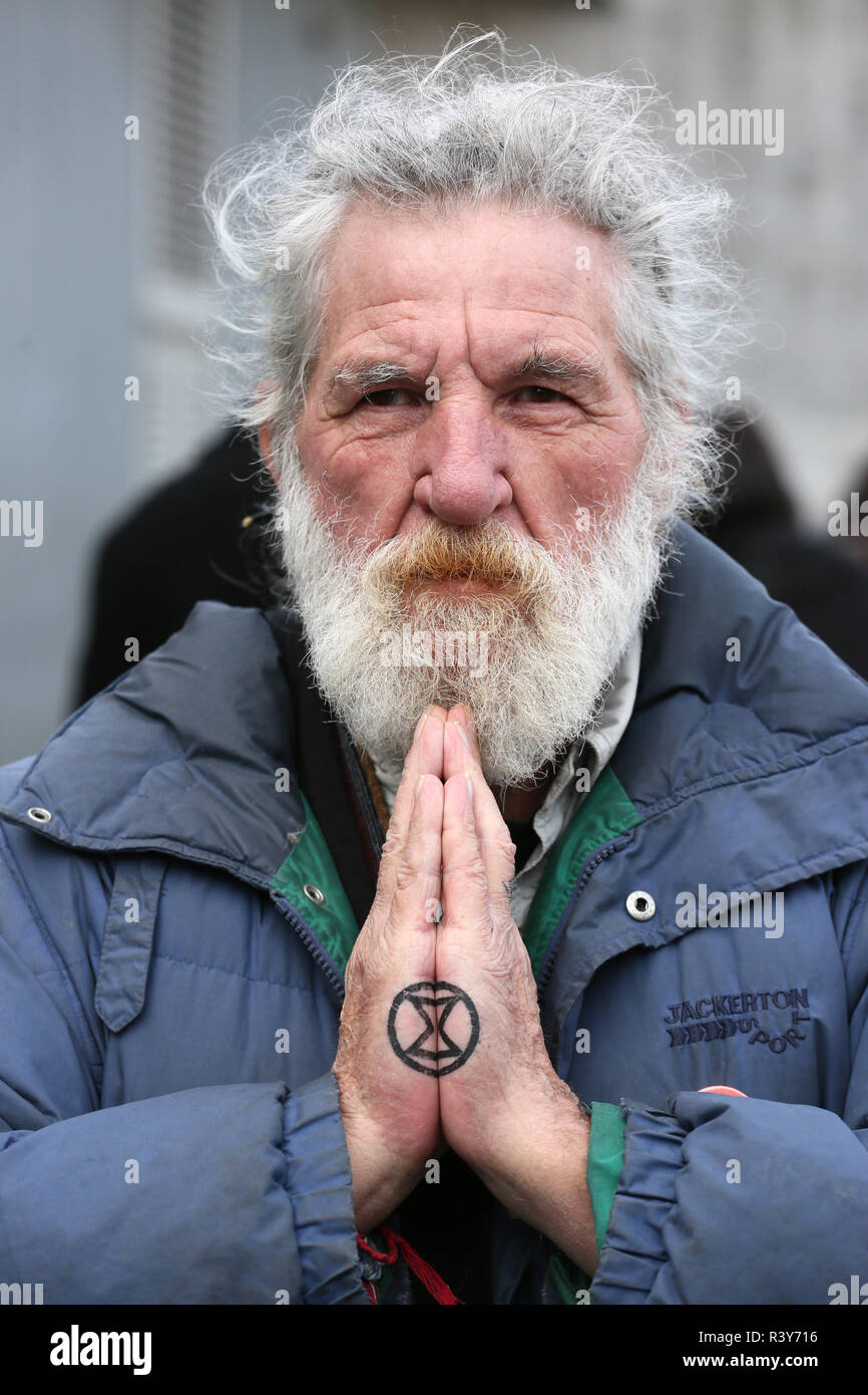 Manchester, UK. 24th Nov 2018. A climate protester with the extinction symbol tattooed on his hands.  The symbol represents the planet with an hourglass inside it depicting time is running out. The climate protesters  marched through the city streets, Manchester, UK, 24th November 2018 Credit: Barbara Cook/Alamy Live News Stock Photo