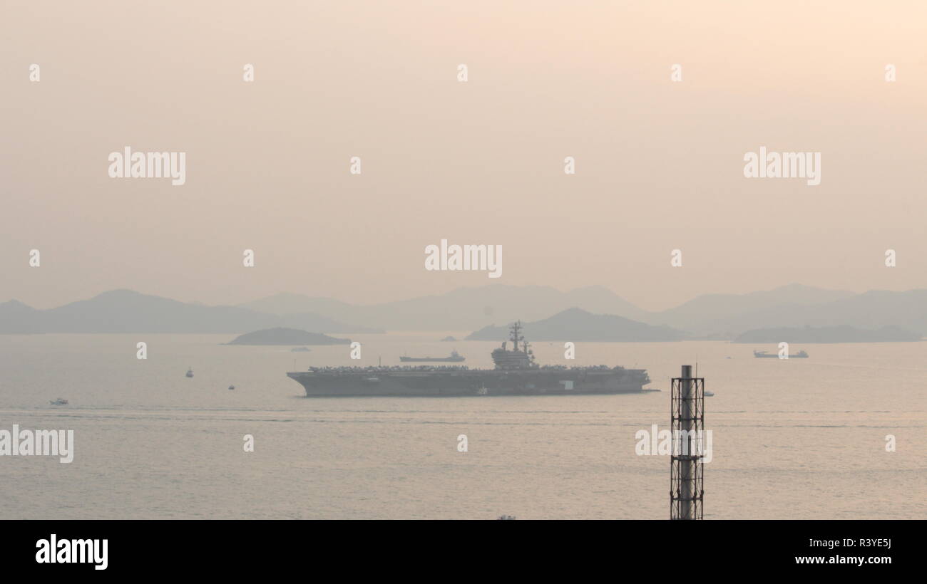 Hong Kong. 24th November 2018. The image represents the aircraft carrier USS Ronald Reagan (CVN 76) anchored near south of the Tsing Yi island in Hong Kong, with some smaller boats near her, the image was shot during sunset on 24 November 2018. Credit: Chun Kit Li/Alamy Live News Stock Photo