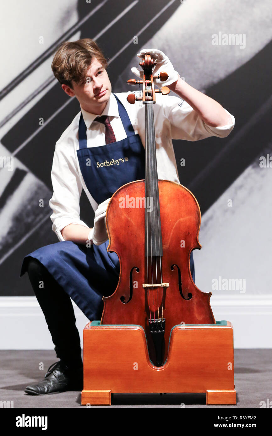 A technician is seen placing Giovanni Battista Guadagnini. A Cello, Turin, 1783 for display as part of the Rostropovich private collection. (est - £1,000,000 - 1,500,000). The auction for Rostropovich Vishnevskaya. The Private Collection takes place London Sotheby's on 28 November 2018. Stock Photo