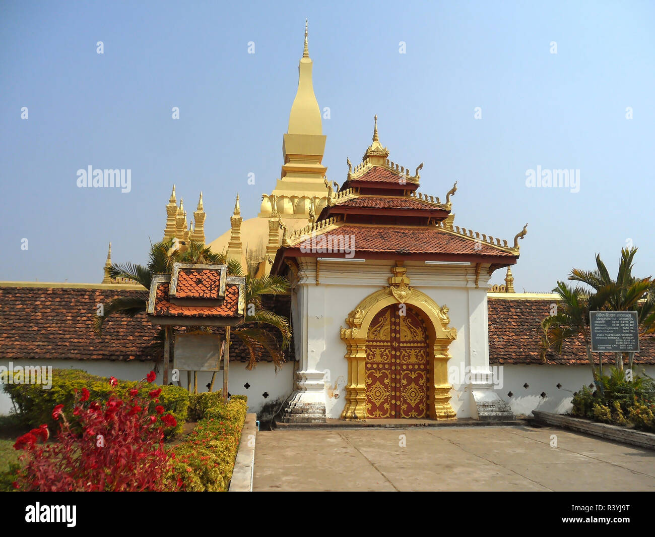 Gorgeous Main Entrance of Pha That Luang or the Great Stupa in Vientiane of Laos, the Board beside the Entrance is the Information of Opening Hours Stock Photo