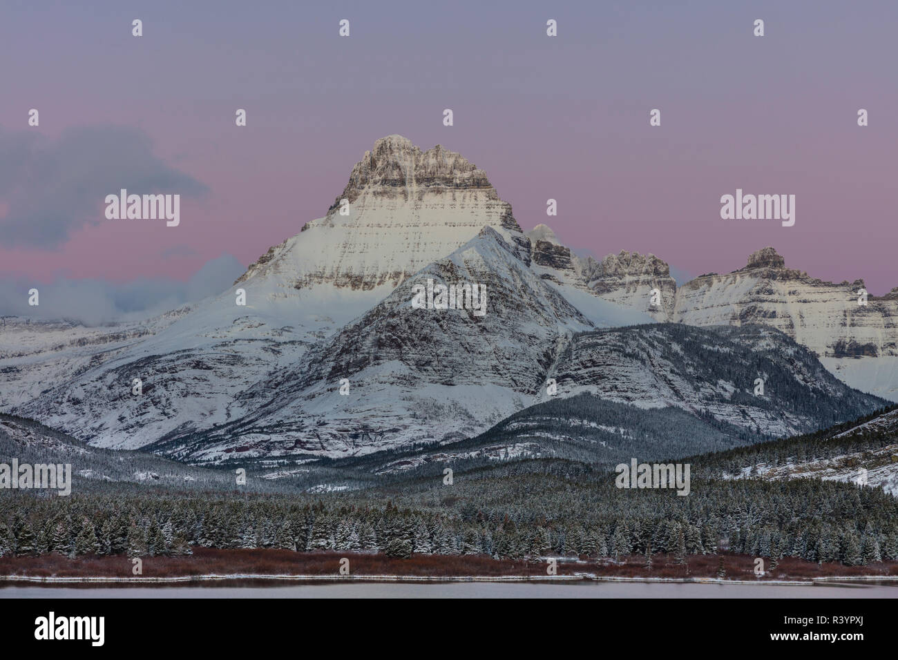 Mount Wilbur above swift current lake at dawn in early winter in Glacier National Park, Montana, USA Stock Photo