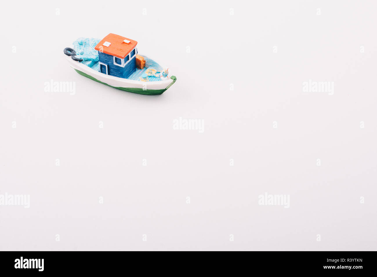 https://c8.alamy.com/comp/R3YTKN/little-colorful-model-fishing-boat-placed-on-white-R3YTKN.jpg