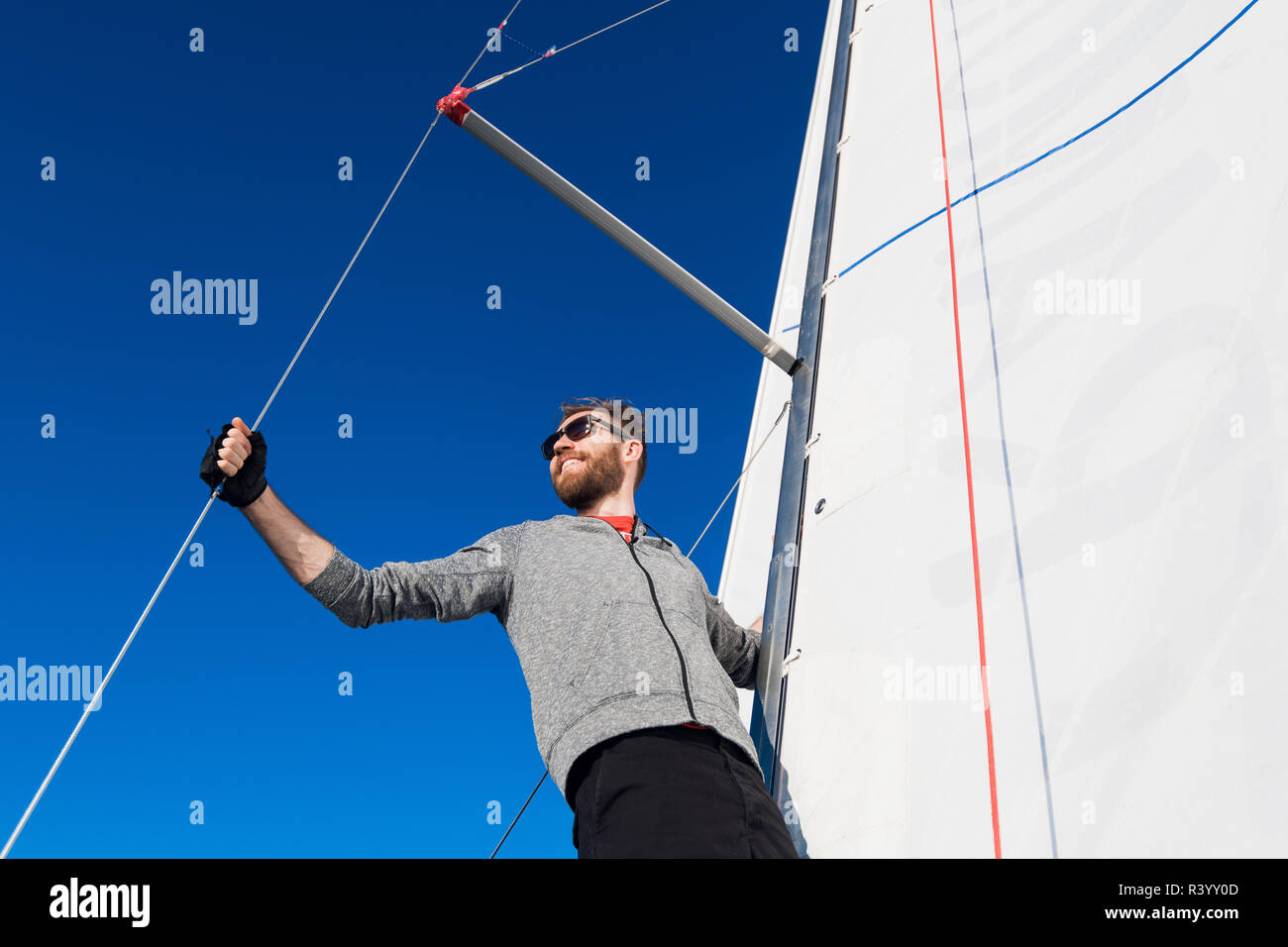 confident captain of sail boat standing and looking out to sea Stock