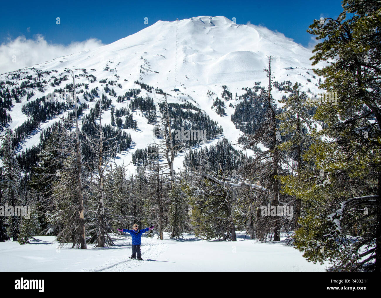USA, Oregon, Deschutes National Forest. Snowshoeing girl and Mt. Bachelor (MR) Stock Photo