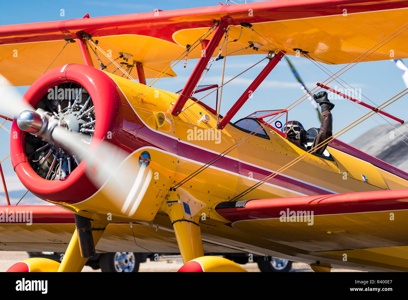 Pilot waving from the cockpit of his biplane, Madras Airshow, Oregon