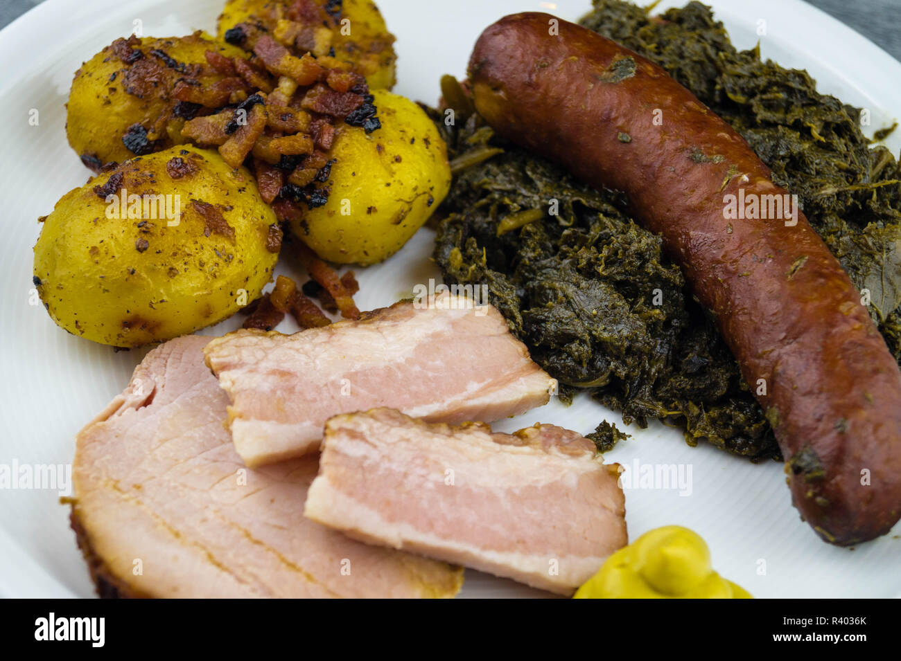 traditional northern german Food curly Kale with pork Bacon and sausages Stock Photo