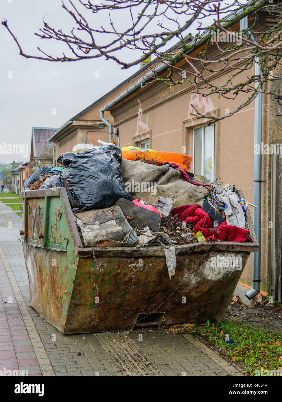 https://c8.alamy.com/comp/R40514/a-large-dirty-metal-waste-container-on-the-citys-street-full-of-waste-R40514.jpg