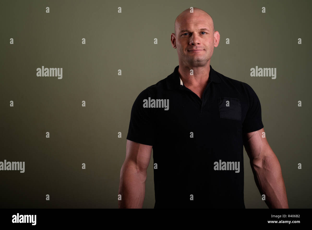 Bald man wearing black shirt against colored background  Stock Photo
