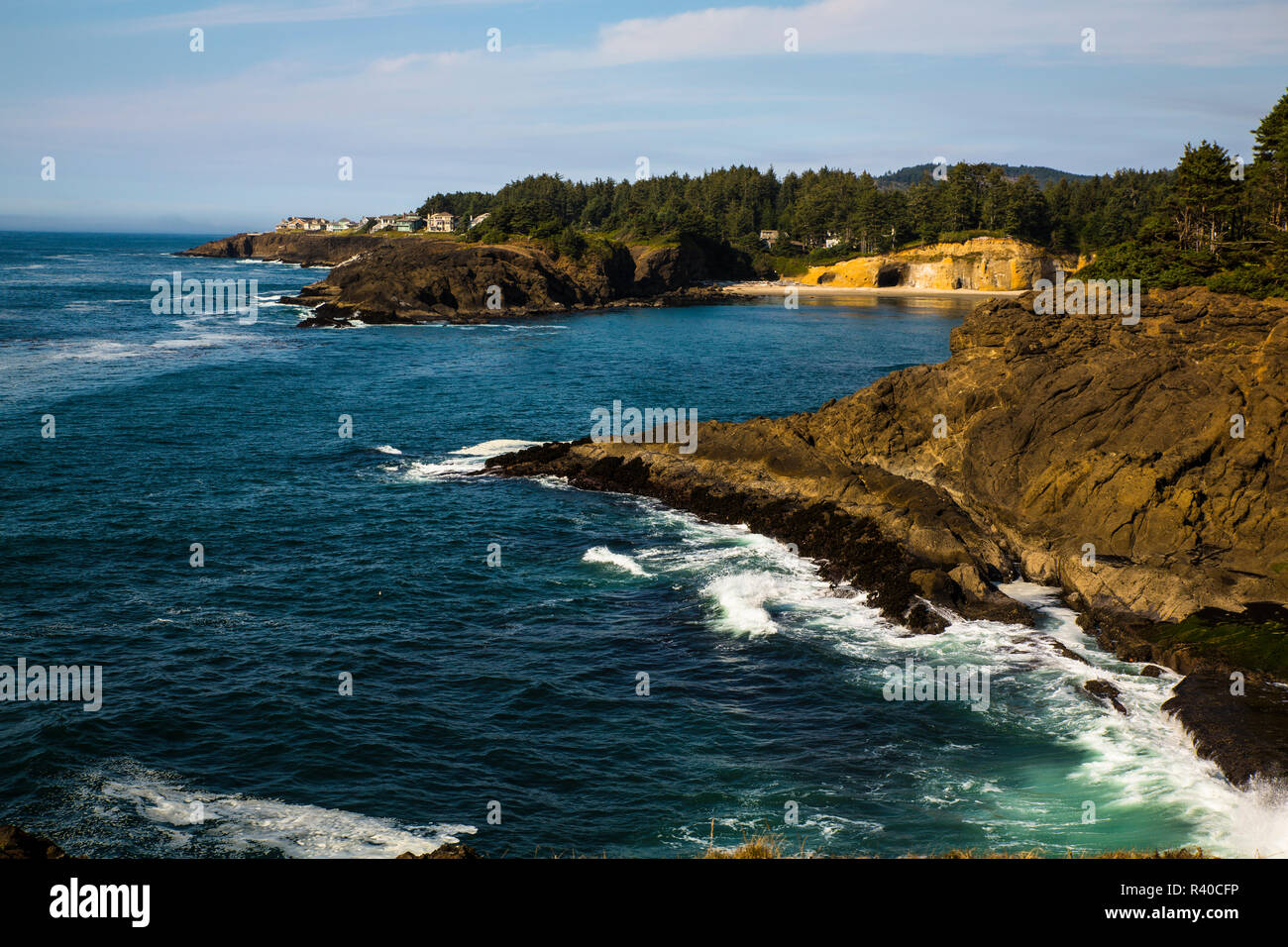 Rugged Oregon Coast, Usa Highway 101, Pacific Coast Scenic Byway. A cave and a cove, houses, and crashing waves Stock Photo