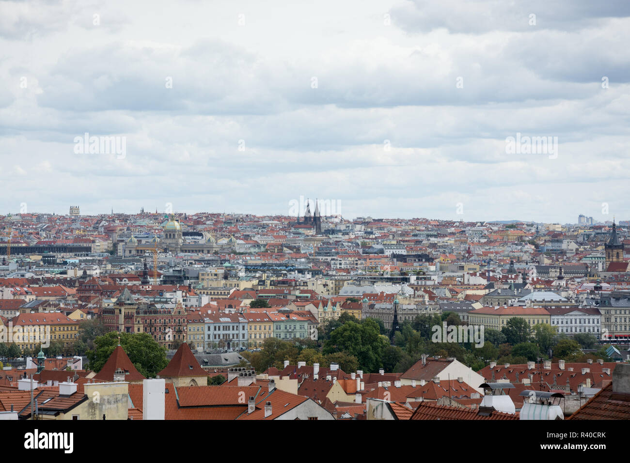 Prague panorama with colorful rooftops on a cloudy day, with The Church of St. Nicholas and Zizkov television tower in the distance Stock Photo