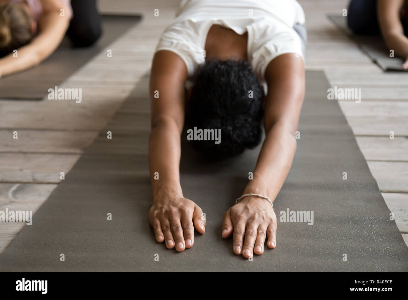 Black yogi woman and group of people doing Child exercise Stock Photo