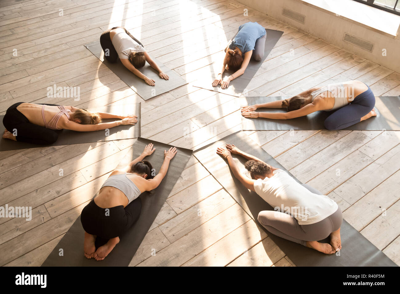 Group of young sporty people practicing yoga lesson, Balasana po Stock Photo