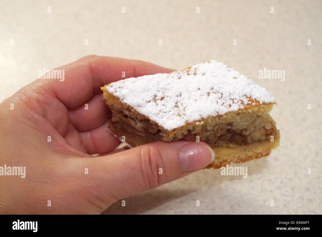 Female hand holding piece of homemade tasty biscuit cake Stock Photo