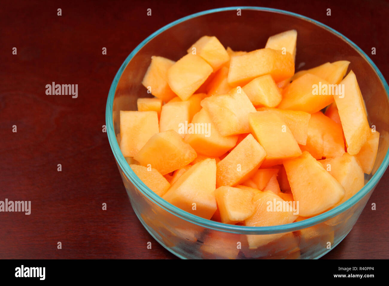 Cantaloupe Pieces in a Clear Glass Bowl on Wood Stock Photo