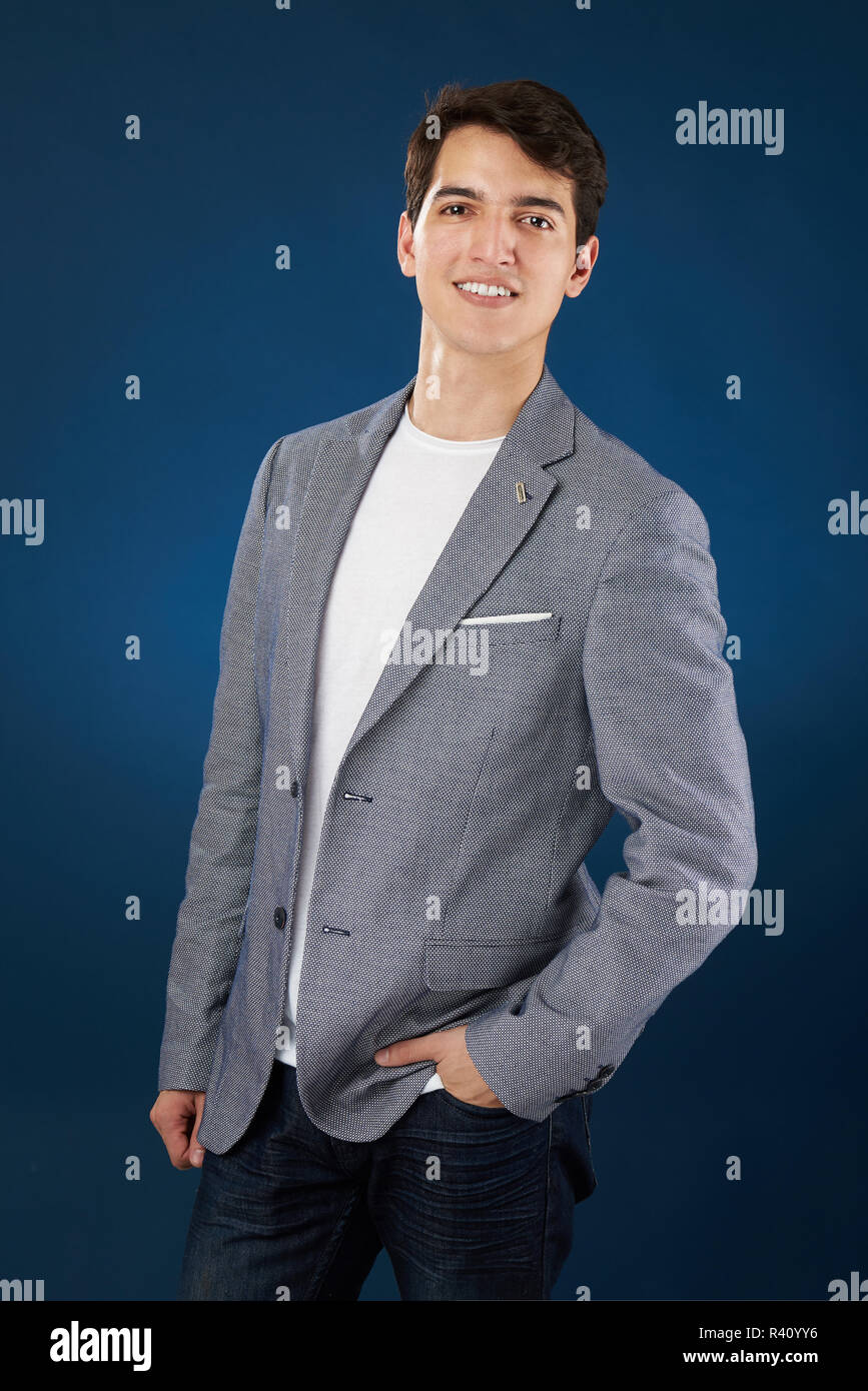 Young man in smart casual outfit isolated on blue studio background Stock Photo