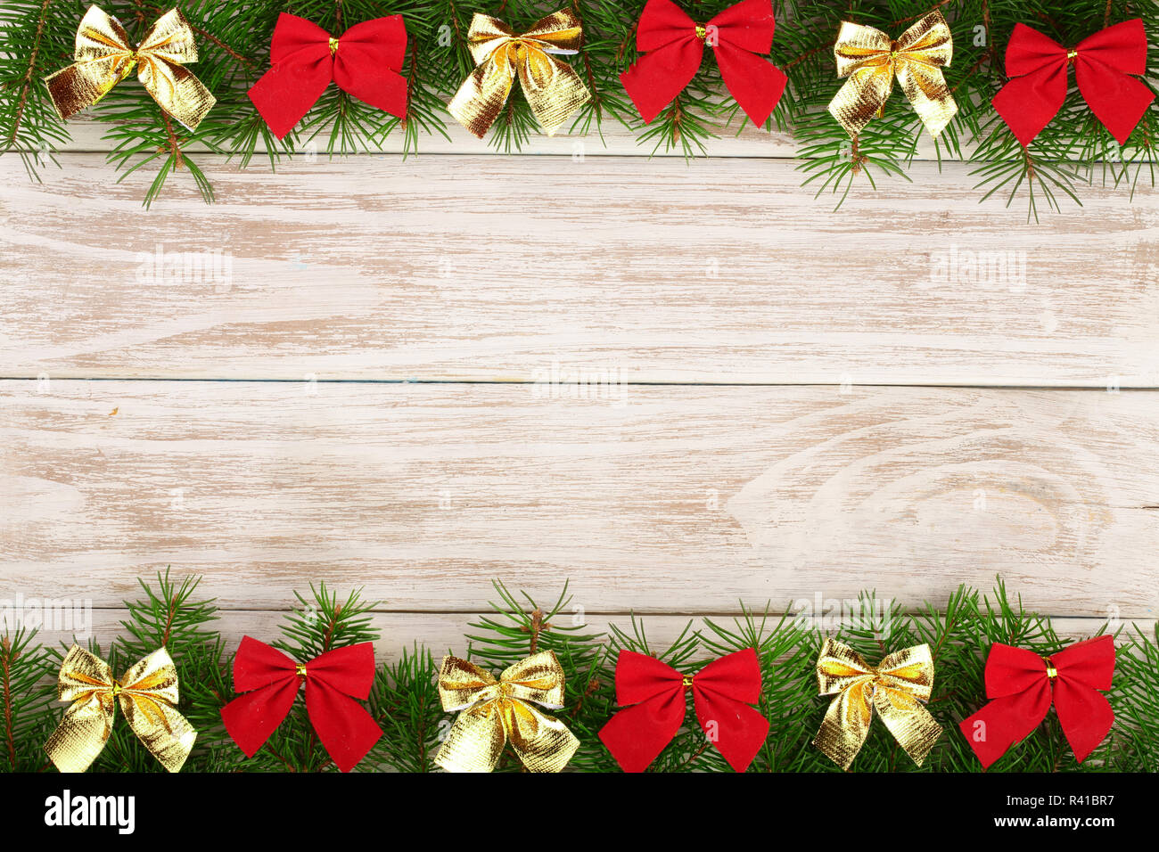 Christmas frame made of fir branches decorated with bows on a light ...