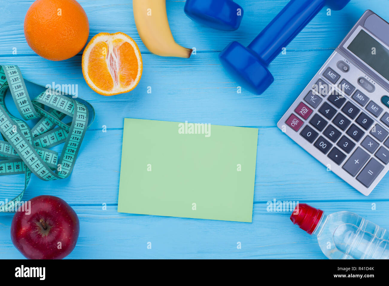 Gym equipment, fruits, measuring tape, calculator. Healthy eating, dieting, slimming and weight loss concept. Stock Photo