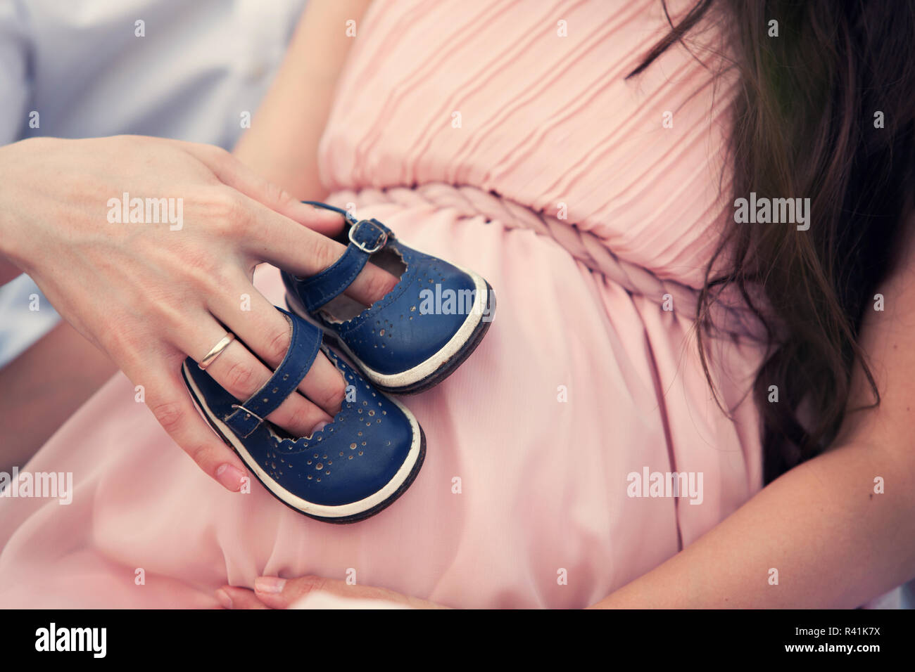 baby shoes on her belly Stock Photo Alamy