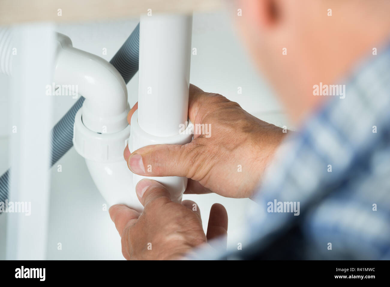 Serviceman Working On Pipes Under Kitchen Sink Stock Photo Alamy