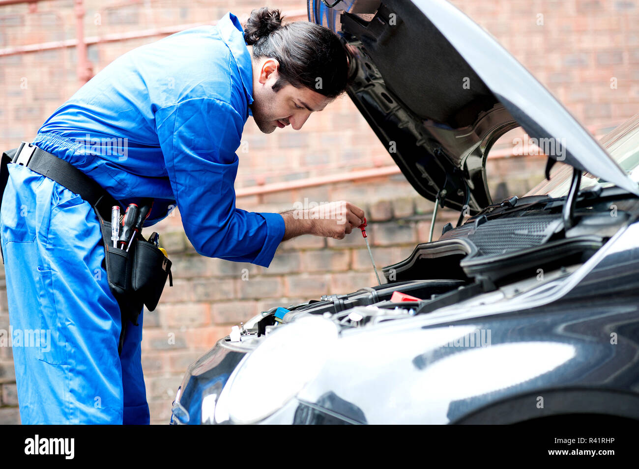 Mechanic tightening the screw, inside car Stock Photo Alamy