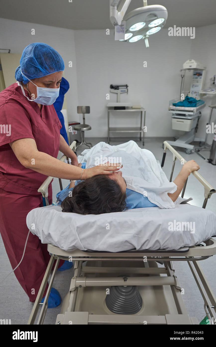 Nurse helping to patient laying in clinic bed Stock Photo - Alamy