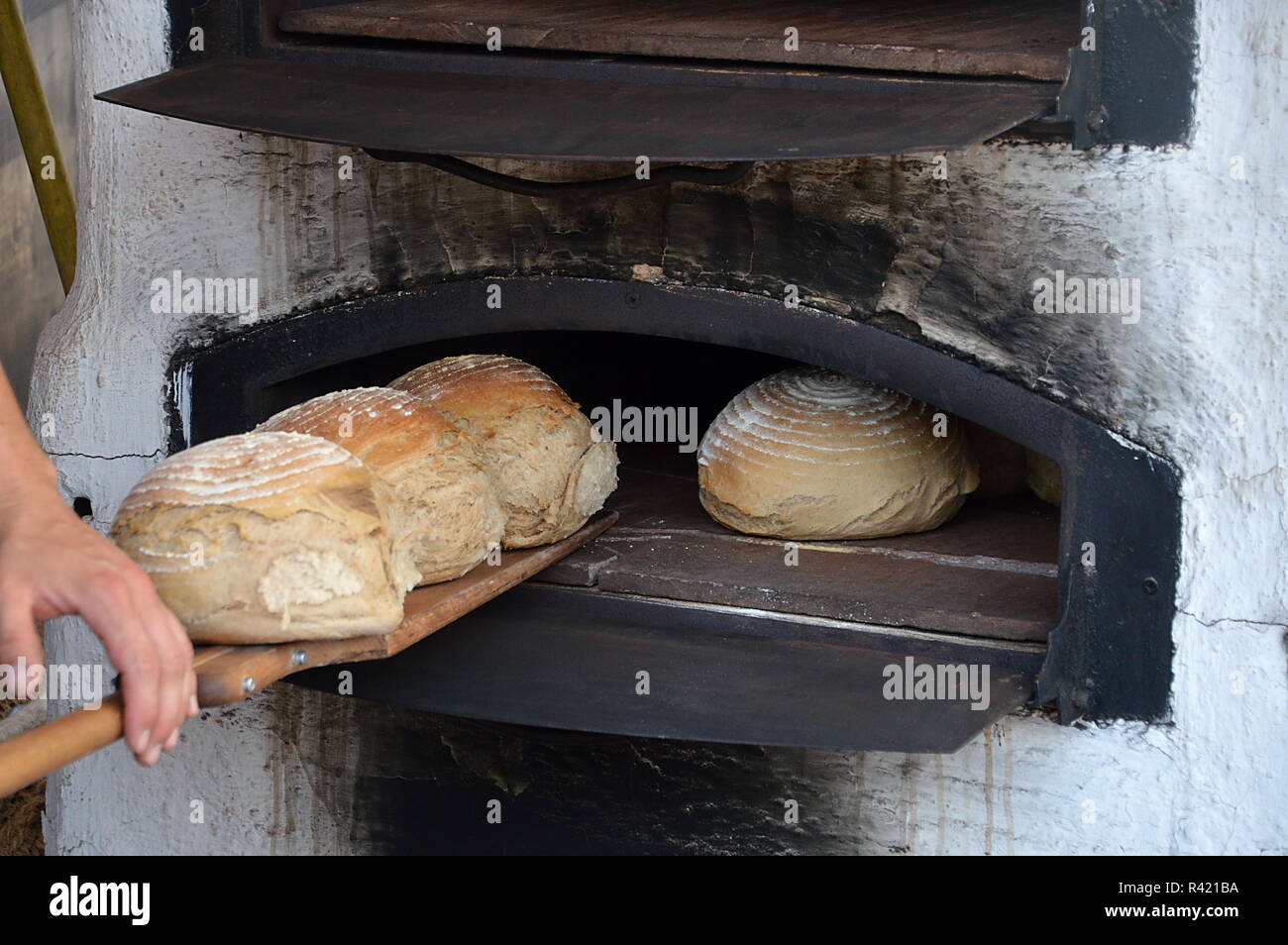 age primitive wood stove with freshly baked loaves of bread Stock Photo