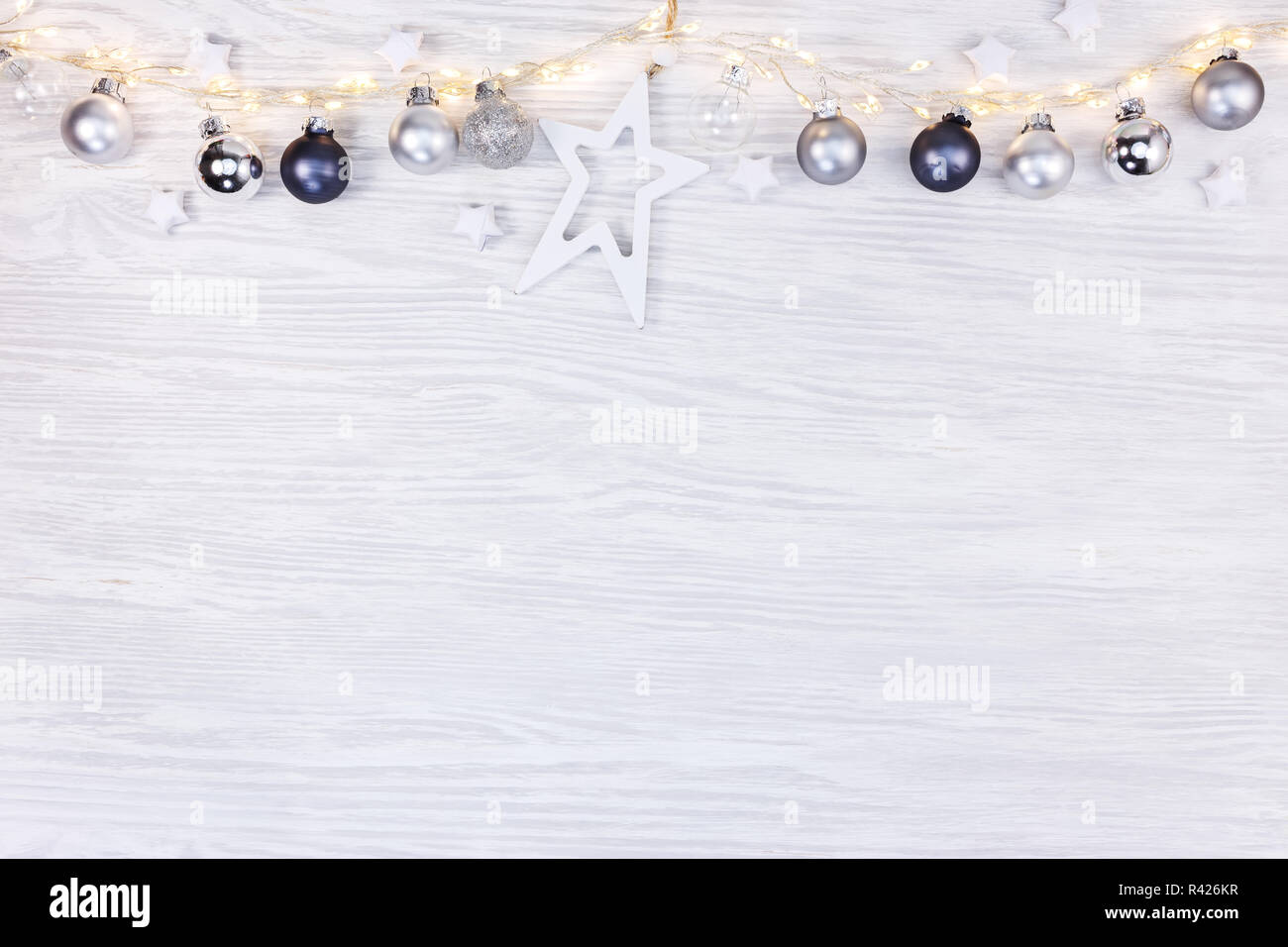 festive winter background with glowing light garlands, christmas tree balls and decorative stars. flat lay view with copyspace Stock Photo