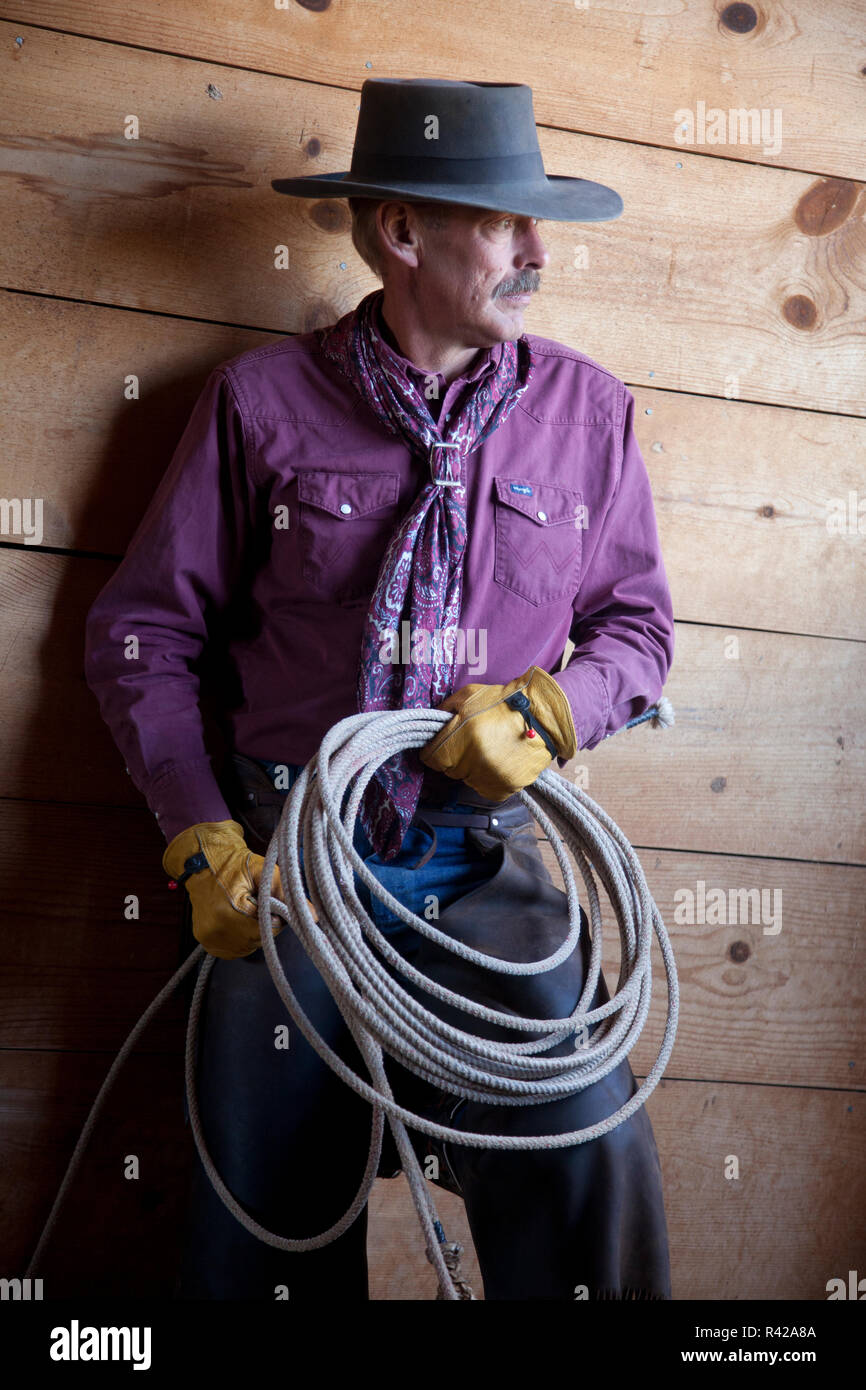 Usa, Wyoming, Shell, The Hideout Ranch, Cowboy with Lasso in Barn (MR, PR) Stock Photo