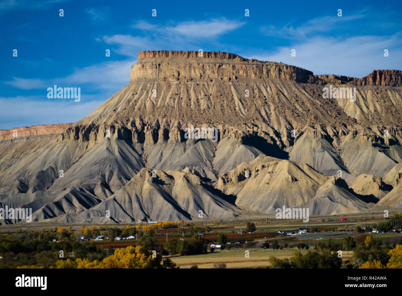 Mount Garfield up against a blue sky with the town of Palisade below