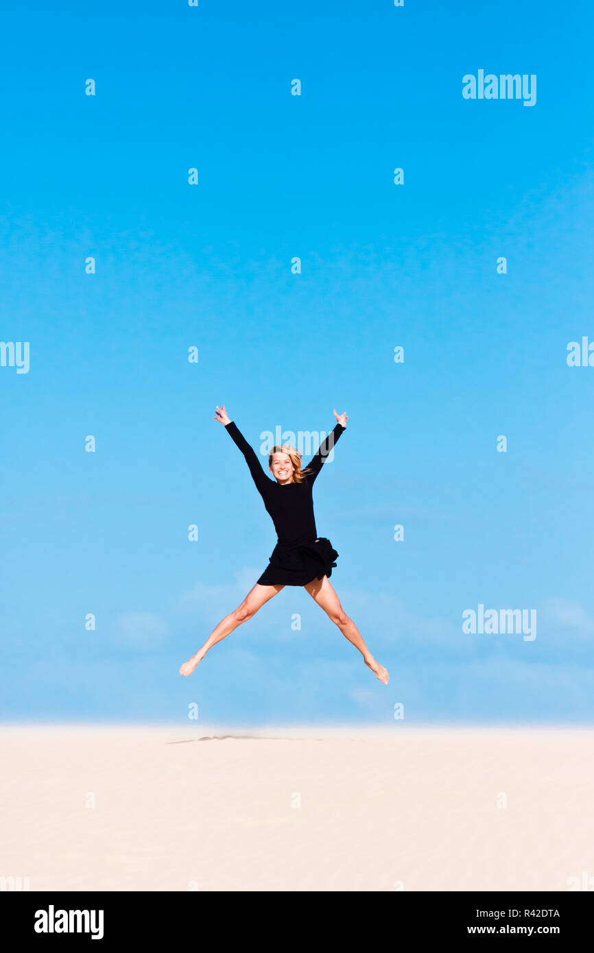 Girl jumping in the air on sand dune Stock Photo Alamy