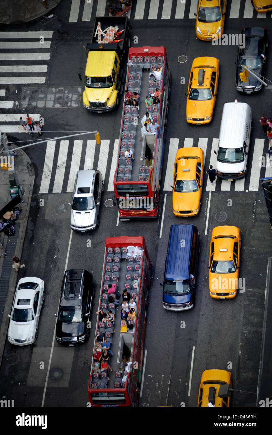 Taxis and open air tour buses are common sights in New York City. Stock Photo