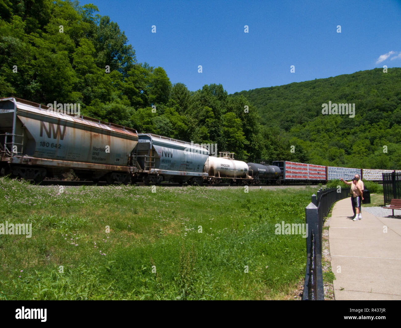 Observers Watch a Passing Train at Horseshoe Curve in Altoona, Pennsylvania.  The Horseshoe Curve is a famous railroad curve built by the Pennsylvania Stock Photo