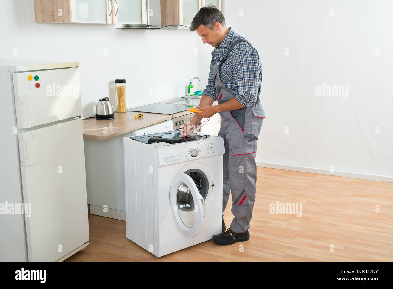 Technician Checking Washing Machine With Digital Multimeter Stock Photo