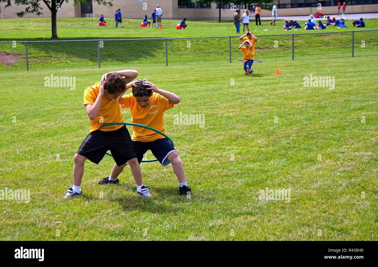 Middletown, CT USA. Jun 2009. Walking boys playing Hula Hoop race or