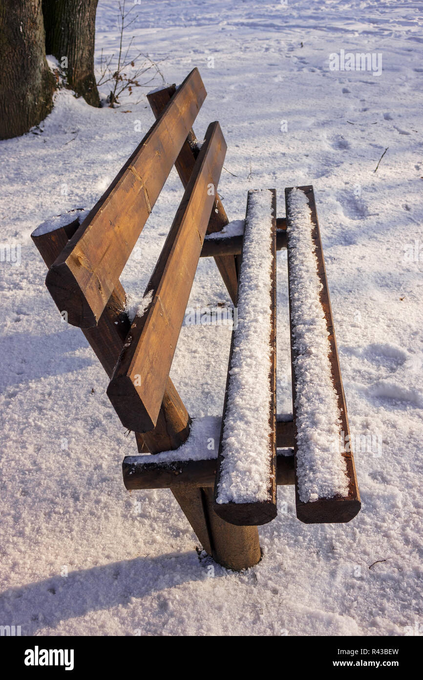 Bench in the park covered with snow Stock Photo - Alamy