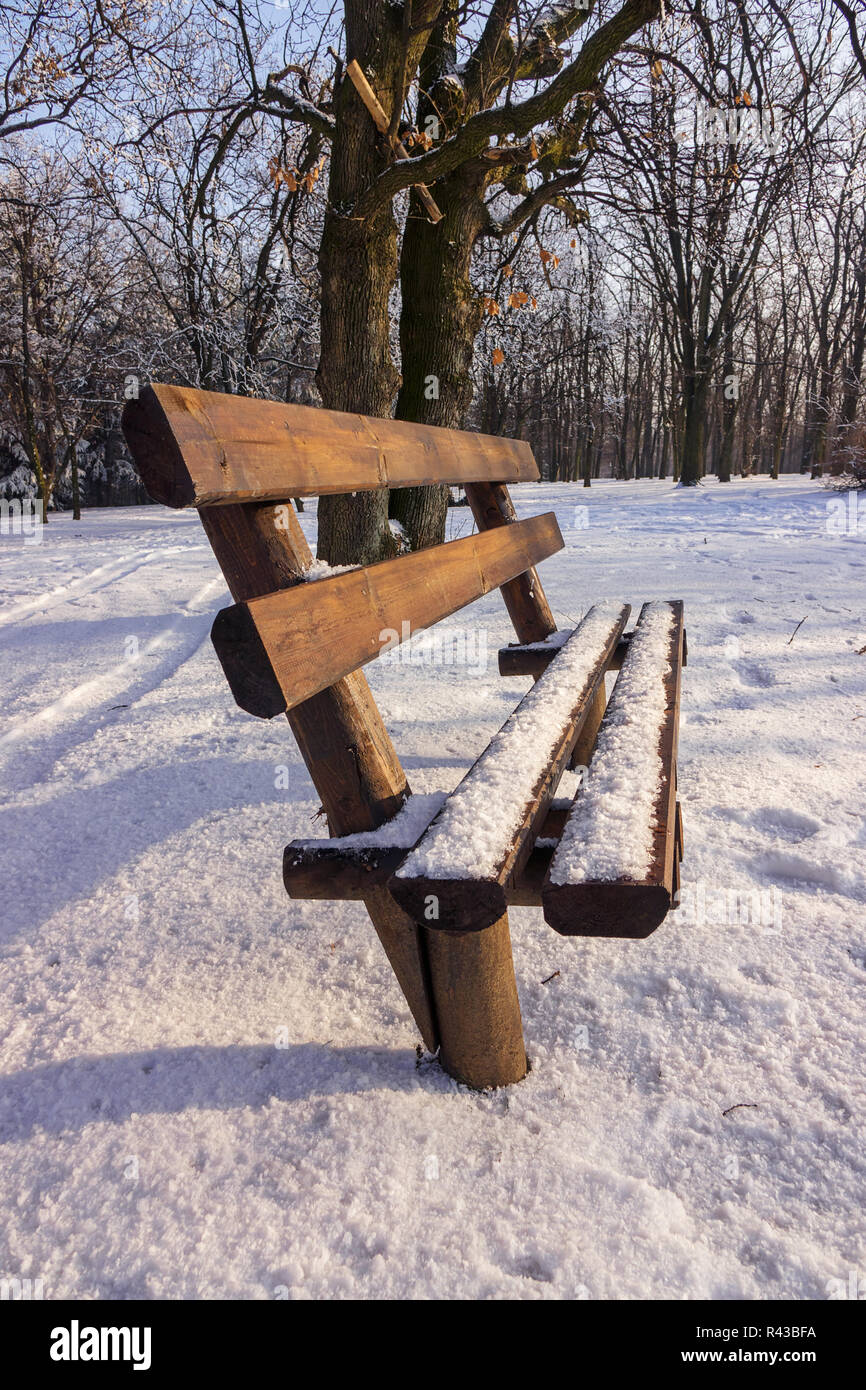 Bench in the park covered with snow Stock Photo - Alamy