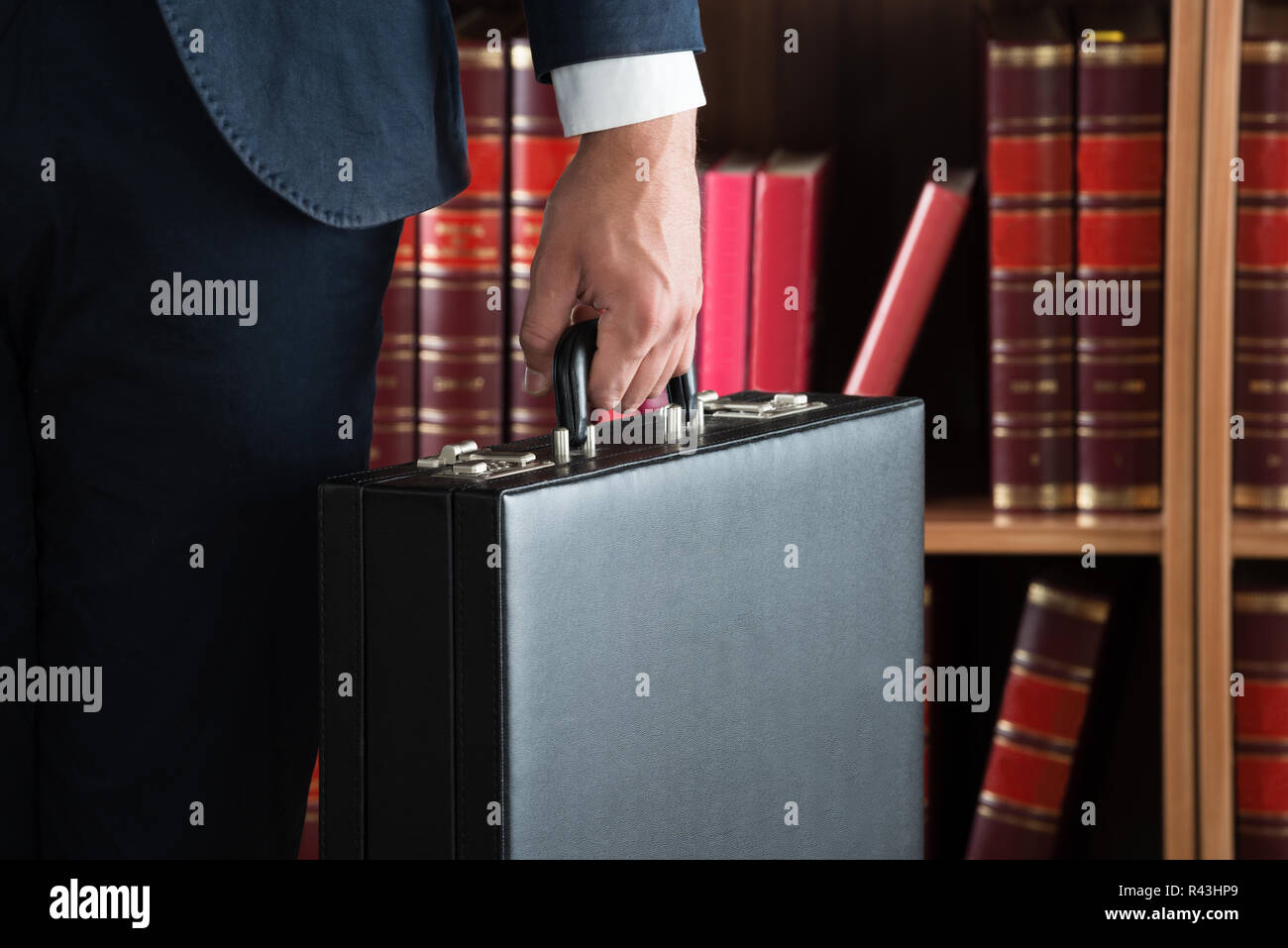 Lawyer Carrying Briefcase Against Bookshelf Stock Photo Alamy