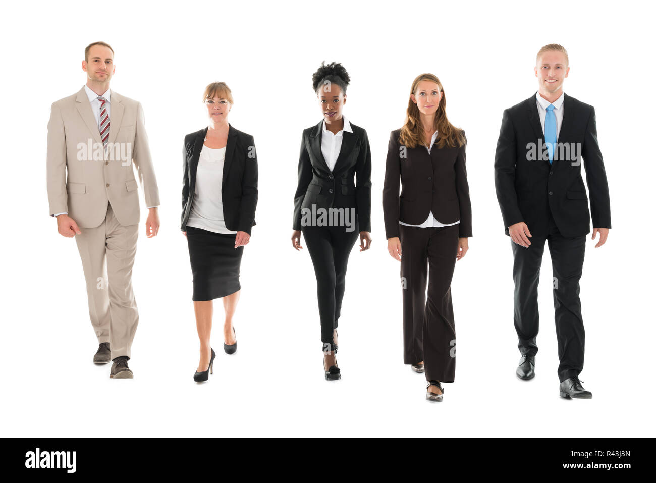 Confident Business Team Walking Against White Background Stock Photo