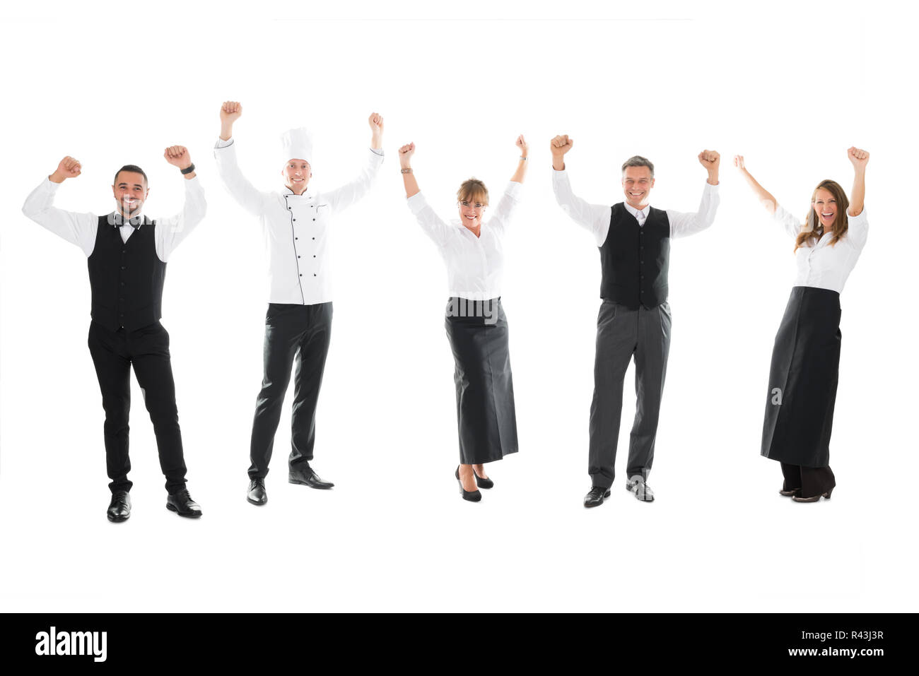 Happy Restaurant Staff Standing With Arms Raised Stock Photo
