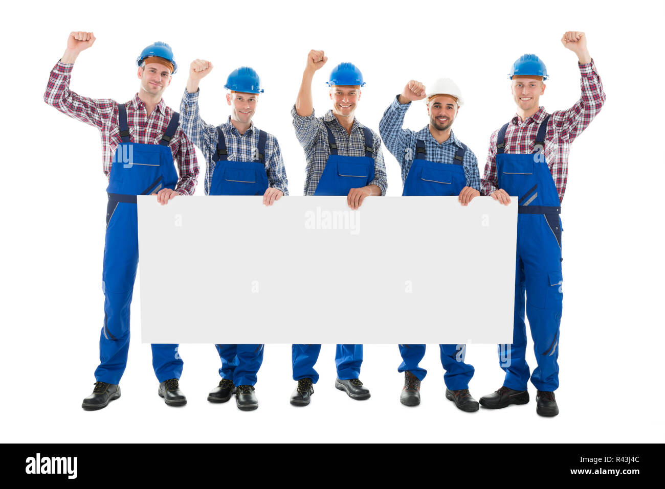 Male Carpenters With Arms Raised Holding Blank Billboard Stock Photo