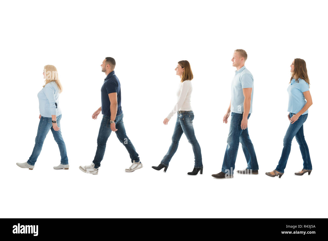 Side View Of People Walking In Queue Stock Photo
