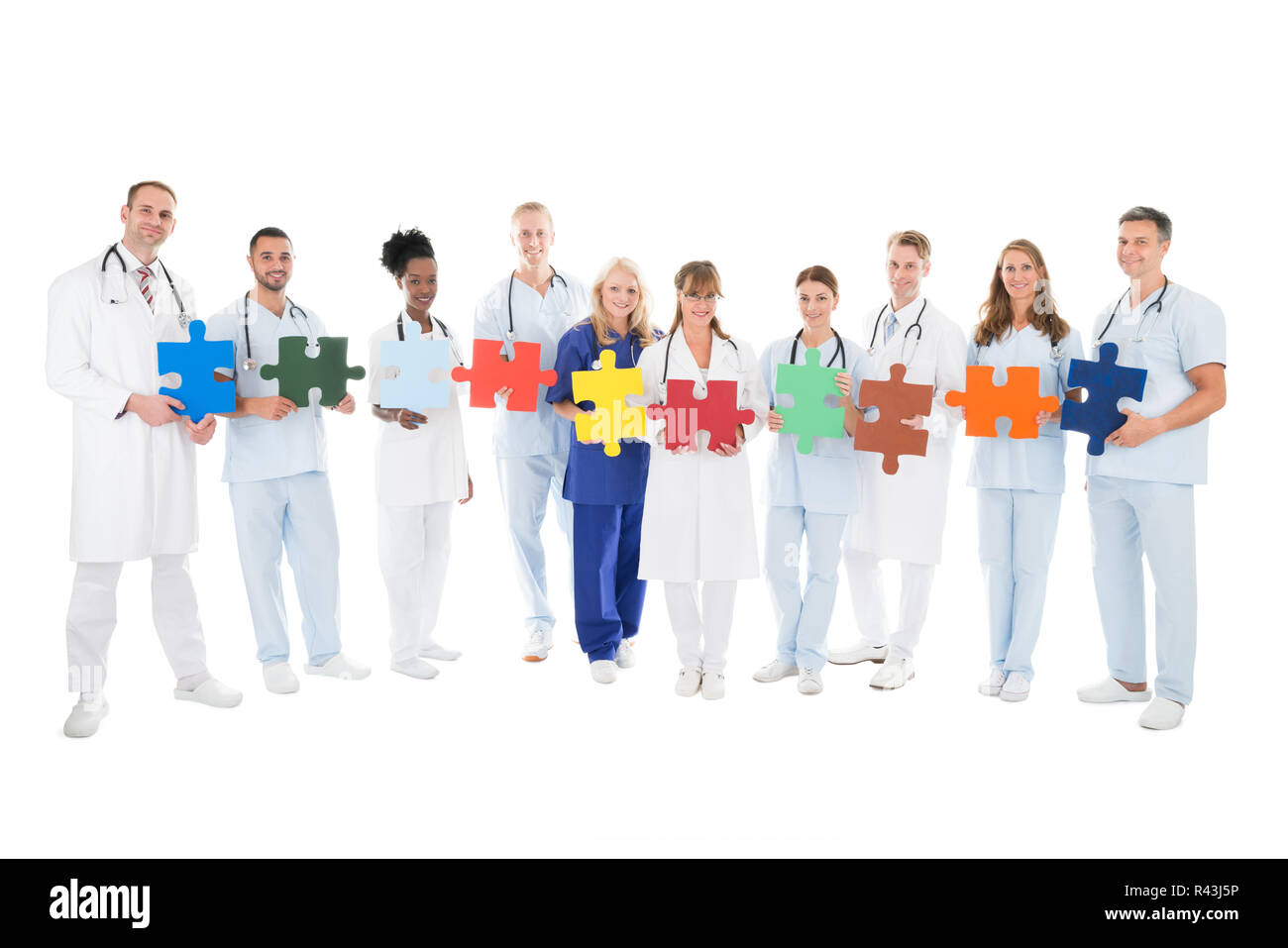 Confident Medical Team Holding Jigsaw Pieces Stock Photo