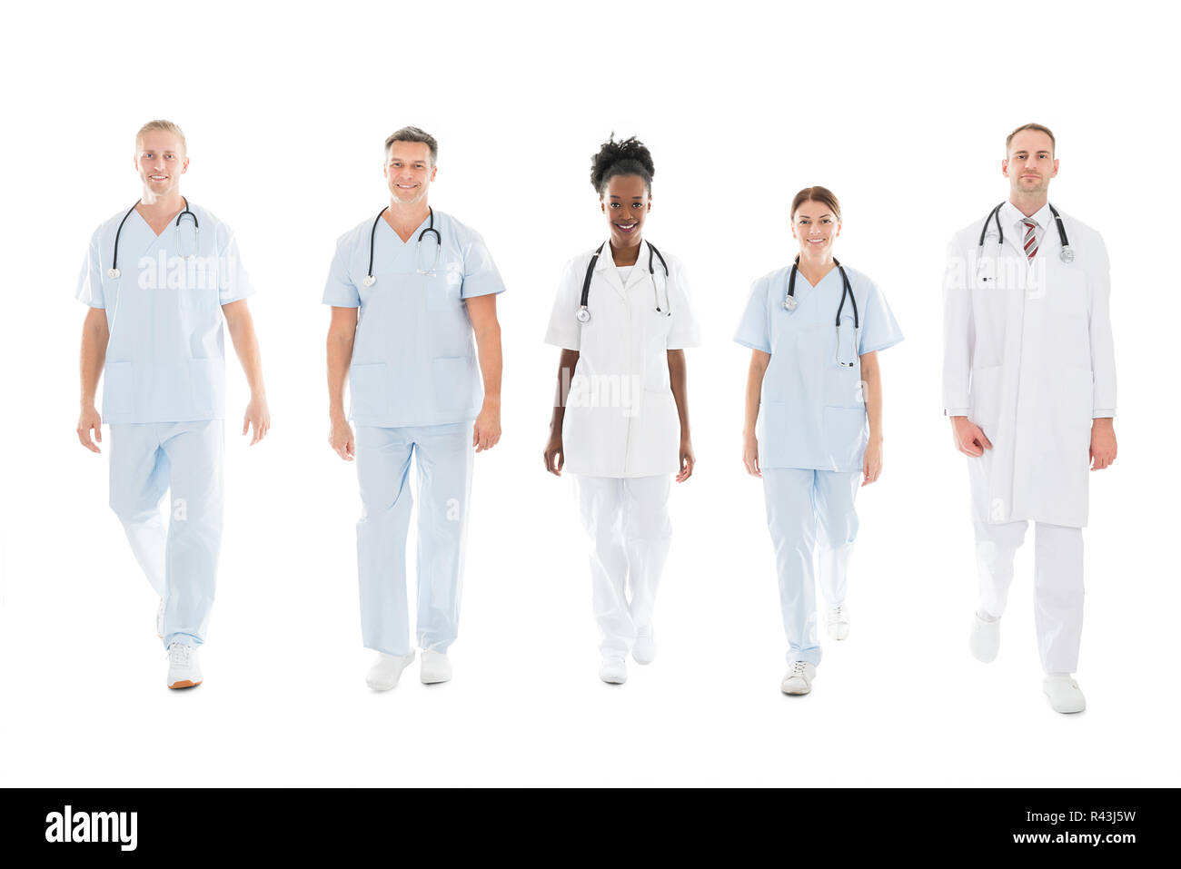 Confident Multiethnic Medical Team Walking In Row Stock Photo