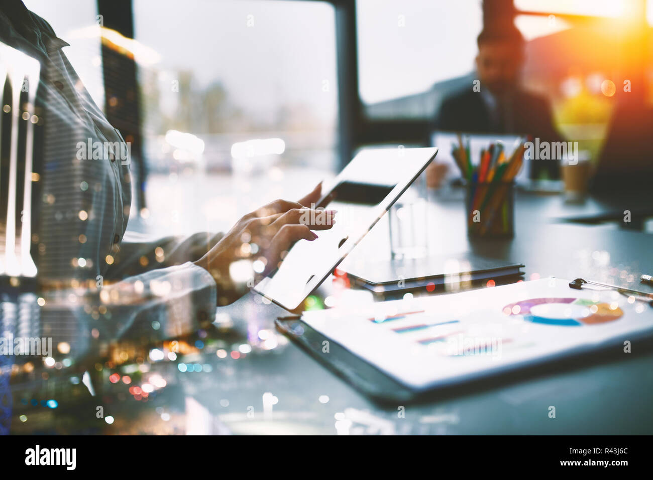 Businesswoman works in office with a tablet. Concept of internet sharing and company startup. double exposure Stock Photo