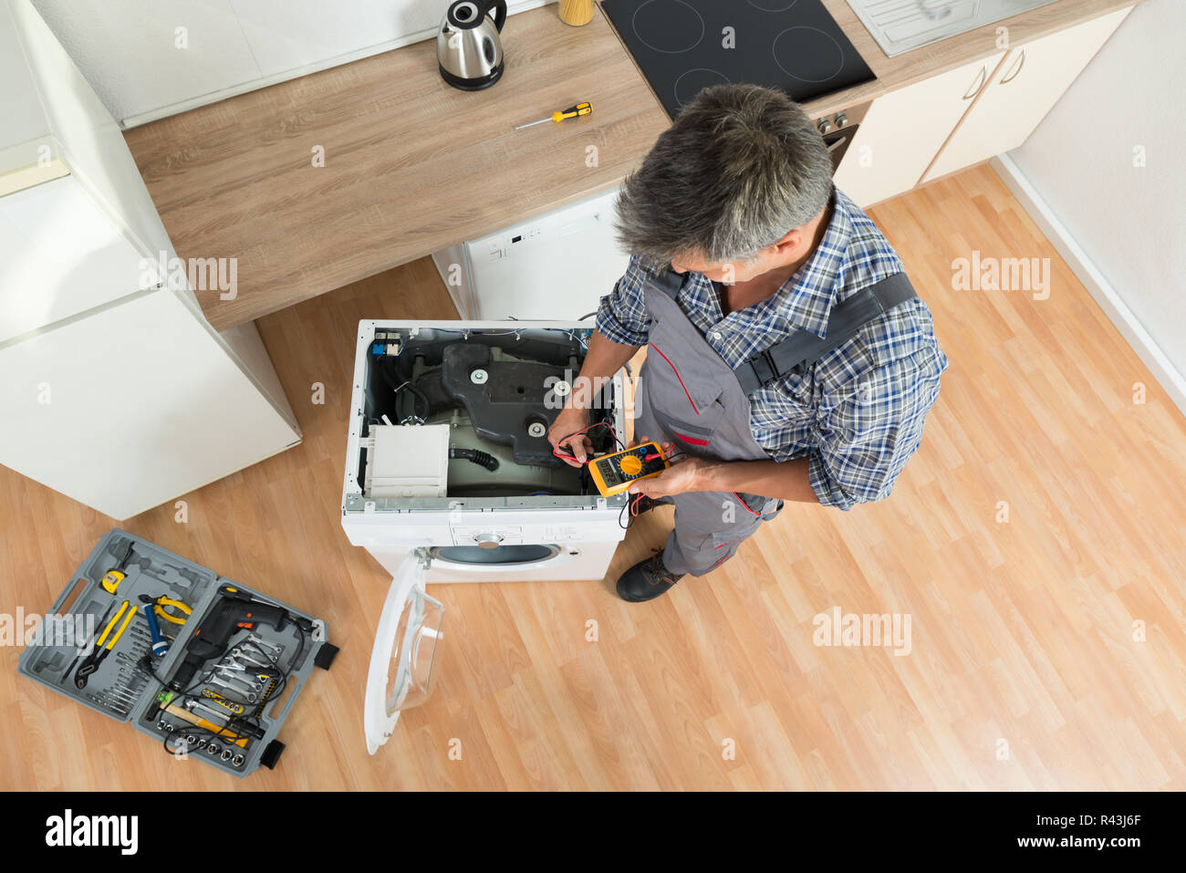 Technician Checking Washing Machine With Digital Multimeter Stock Photo