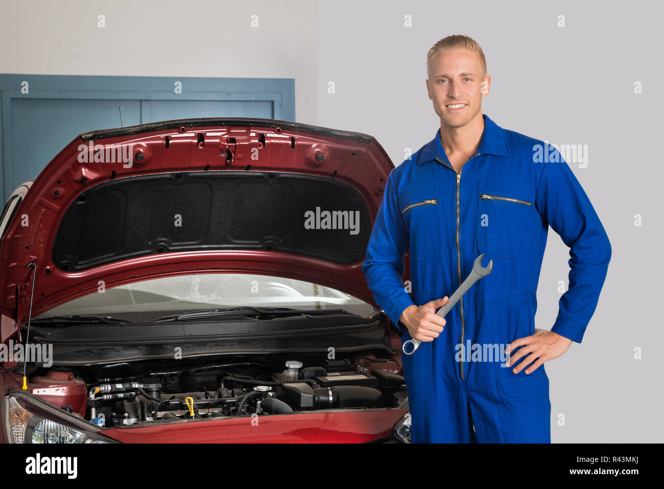 Smiling Mechanic Standing In Front Of Car Stock Photo