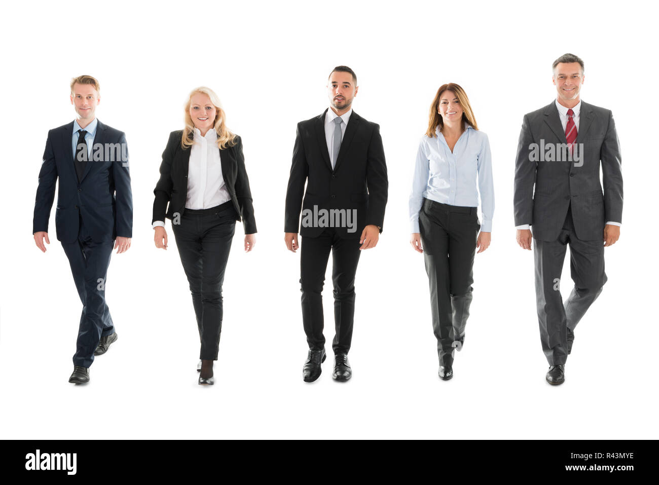 Confident Business People Walking Against White Background Stock Photo