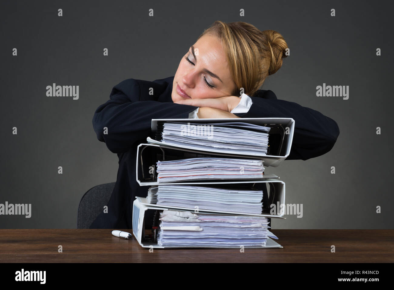 Businesswoman Sleeping On Stacked Binders Stock Photo - Alamy