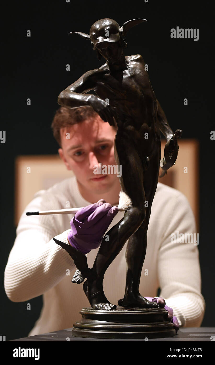 Gallery technician Tim Matthews dusts a bronze statue of Greek hero Perseus by Sir Alfred Gilbert, who famously sculpted the Eros statue in Piccadilly Circus, as it goes on display in the 'Collecting and Giving: Highlights from the Sir Ivor and Lady Batchelor Bequest' exhibition at the Fitzwilliam Museum in Cambridge. Stock Photo