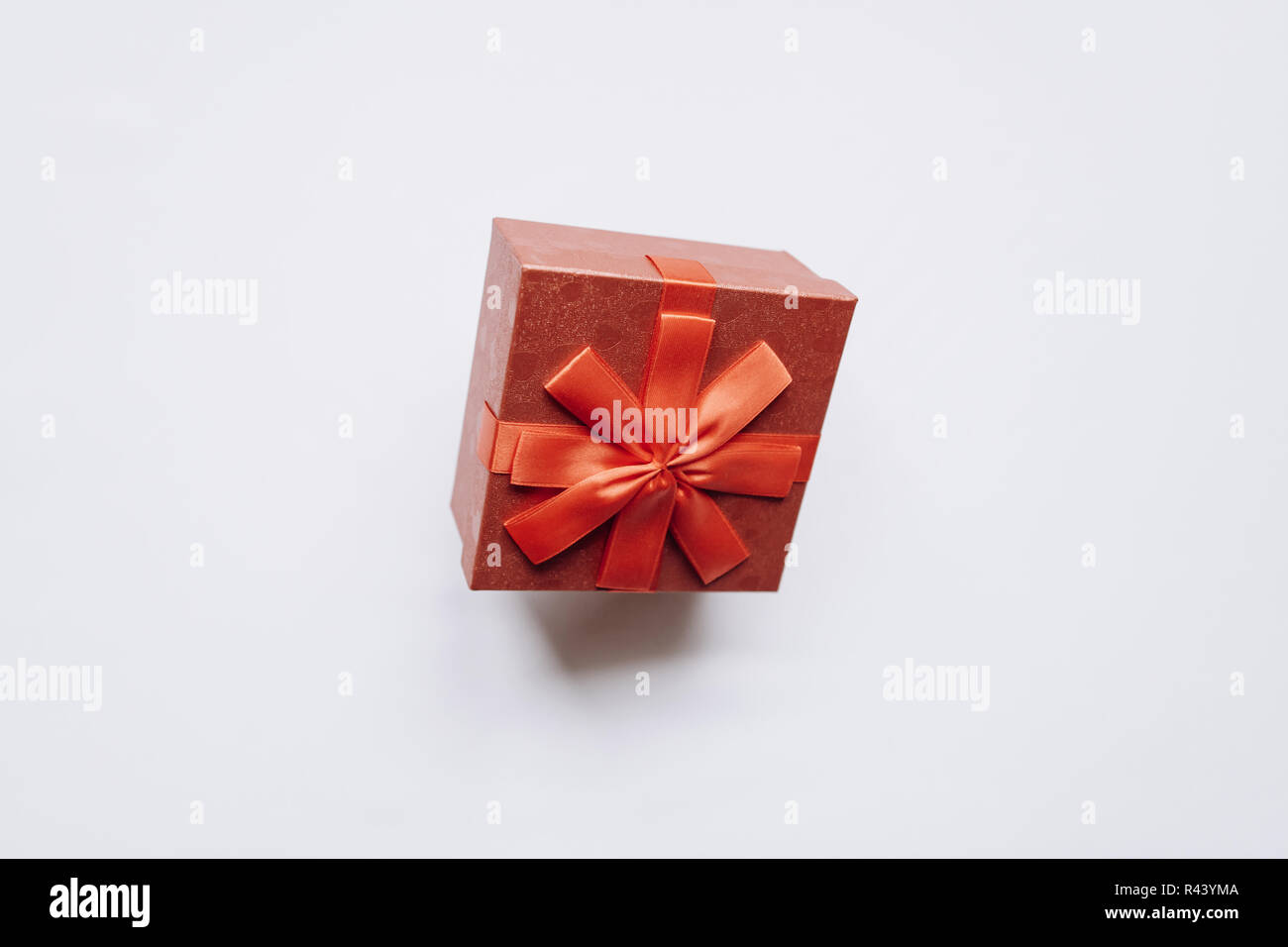 Red box with a bow with a gift on a white background Stock Photo - Alamy